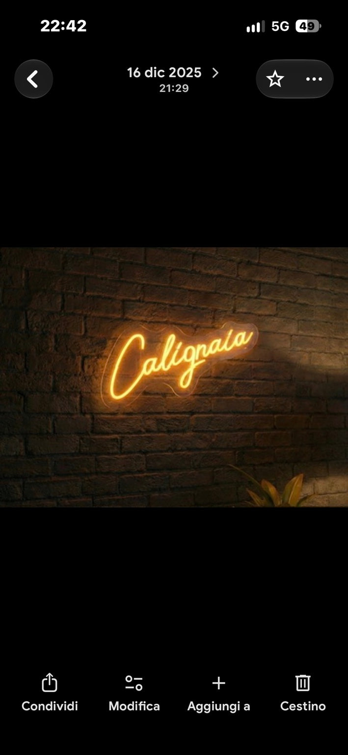Calligraia: scritta al neon su una parete in mattoni
